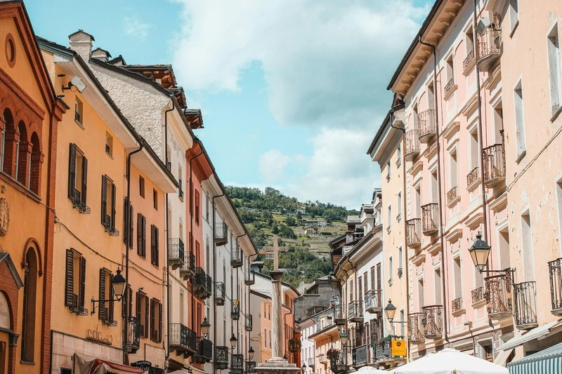 colorful buildings and mountains aosta italy