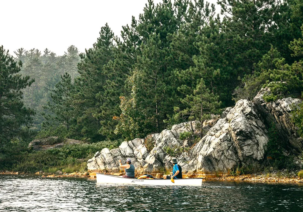 Man and woman paddling on a canoe. Temagami Ontario